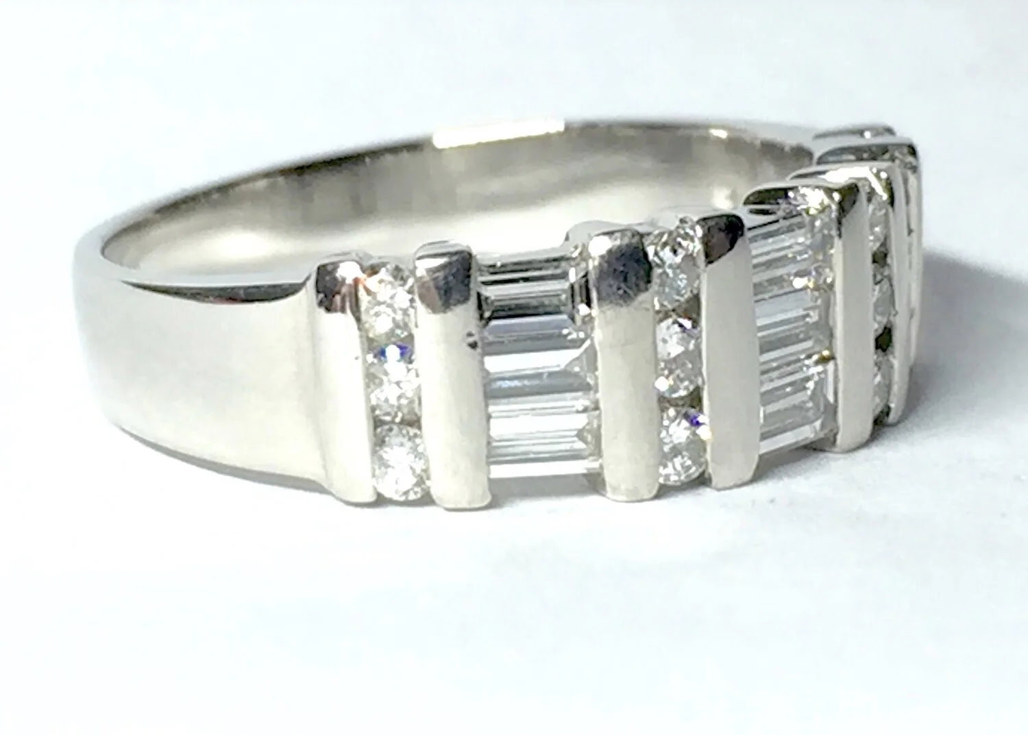  Image 7 and 8. Before and After. A brutally damaged ring with a broken baguette diamond that clearly shows many large impact marks. Our skilled workshop were able to replace the broken stone and re-finsh and shape the platinum setting bars and the shank. 