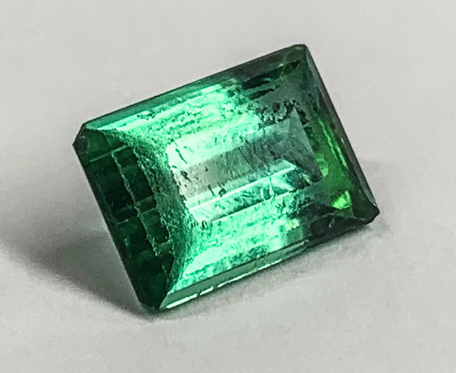  Image 12. A green tourmaline unset from a ring which shows abraded facets and scratches. This was from many years of wear. 