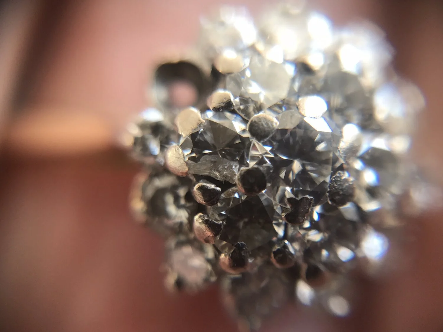  Image 16. General wear and tear on this cluster ring but along the way one of the diamonds has had a bad knock and broken. The other stone has fallen out because the claw holding had worn thin and broken off. 