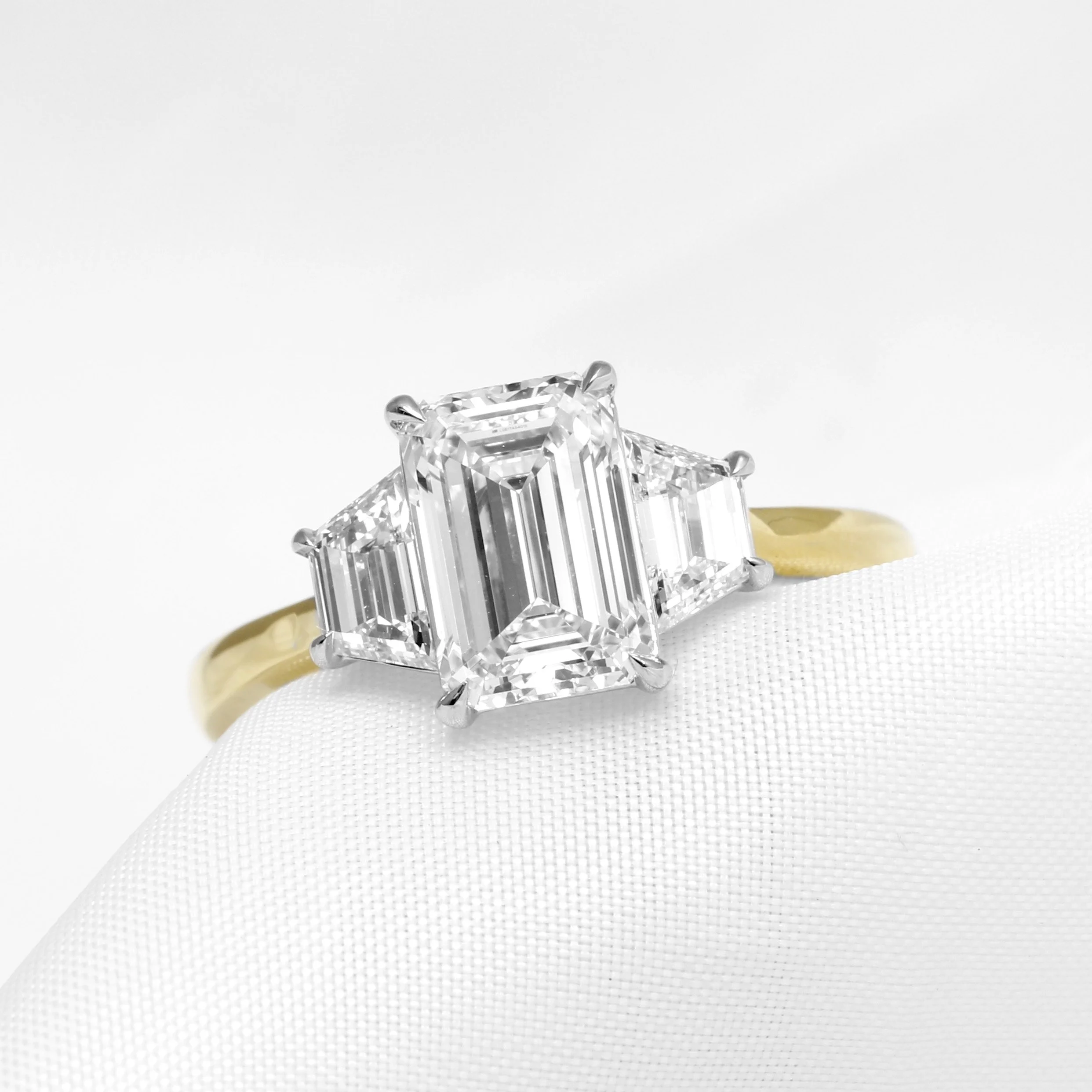   Grace’s  engagement ring made by Timothy Roe: 18 ct yellow gold with platinum head featuring a stunning 2.50 ct laboratory-created emerald cut diamond centre and 0.50 ct laboratory-created trapeze cut diamonds either side 