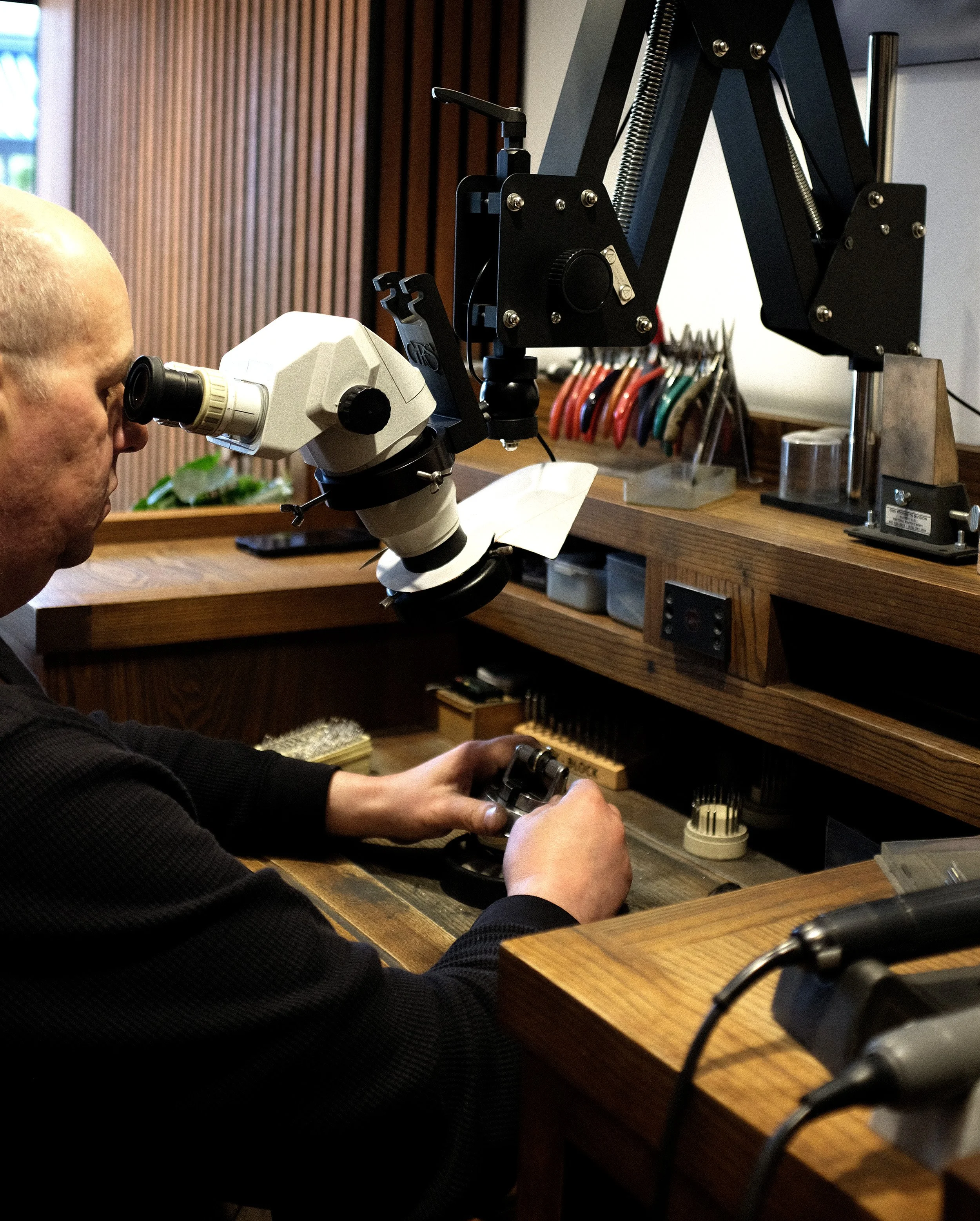  Karl inspecting the stones in a ring at his bench  