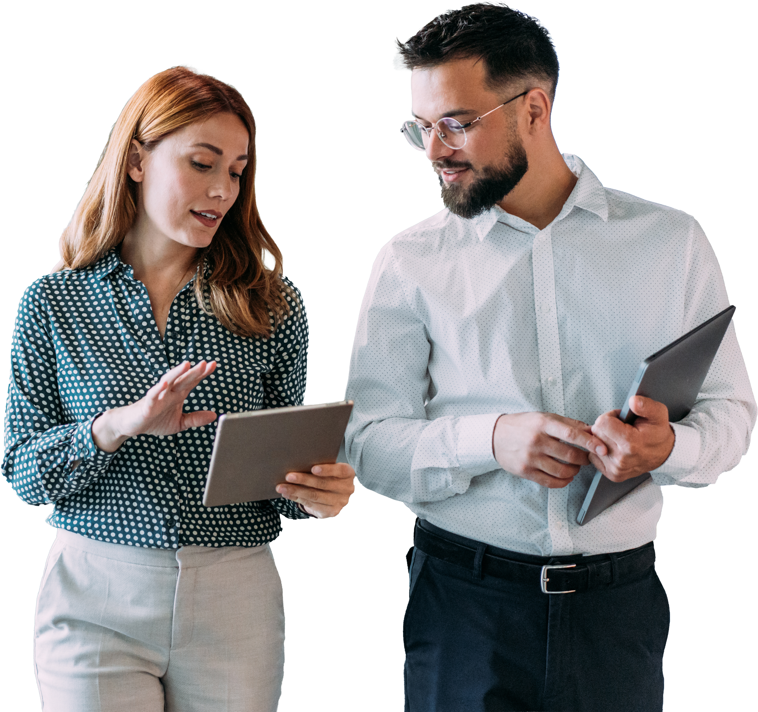 A man and woman, both dressed in professional attire, are looking at tablets and discussing something together.