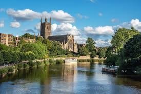 Cathedral by a river with trees and blue sky