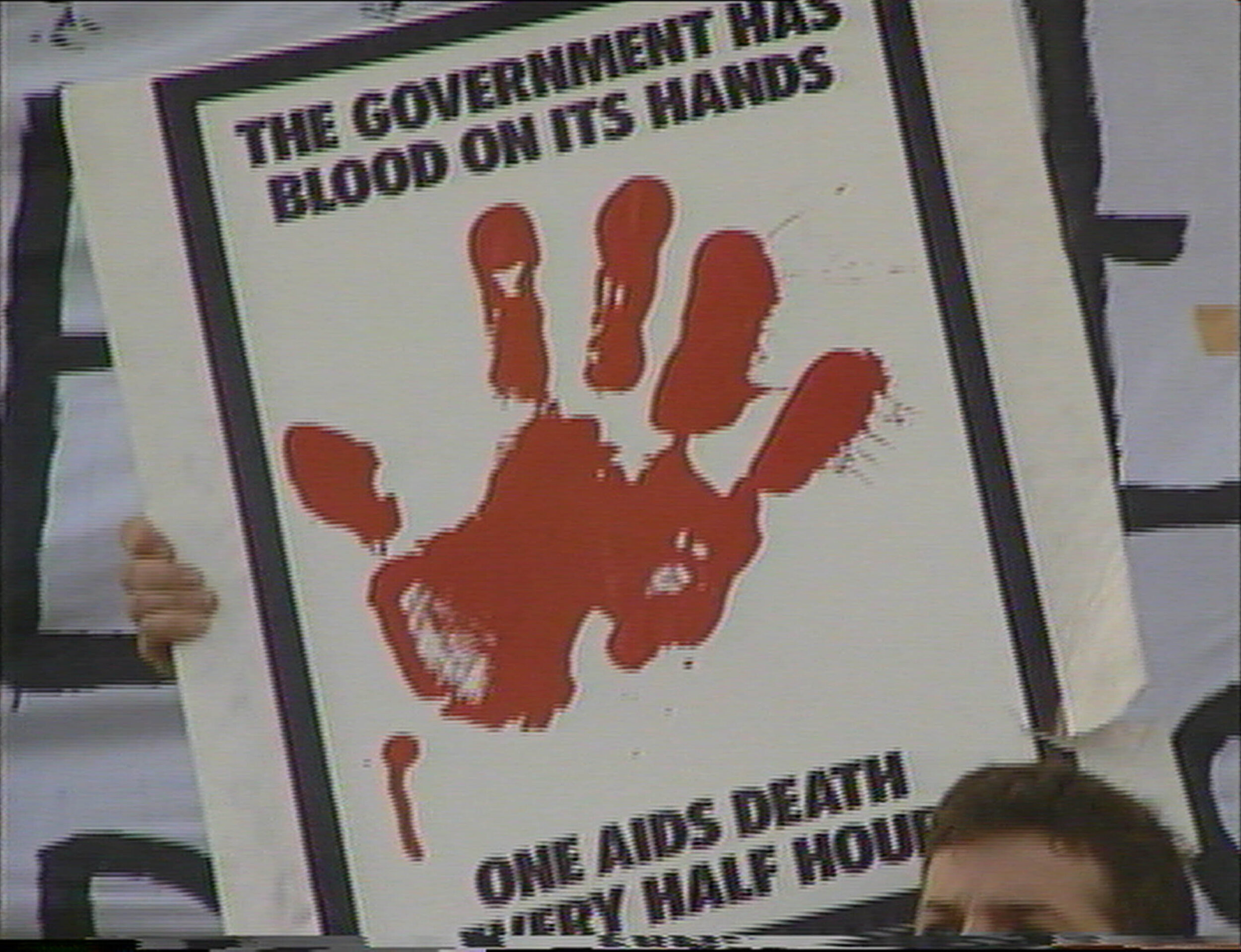 Sign held by ACT UP protester saying 'The government has blood on its hands--one death every half hour'