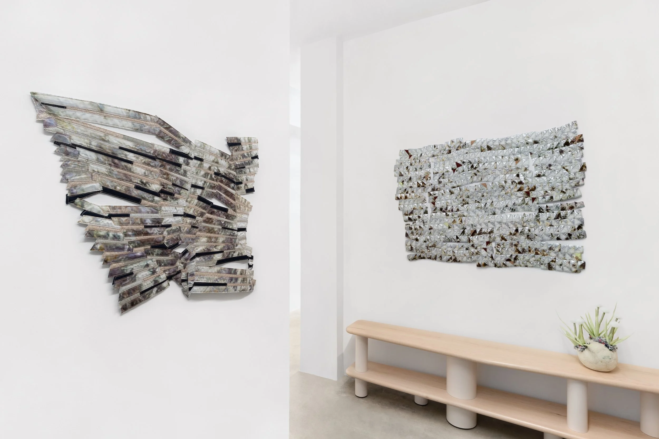 Baker–Hall Gallery - Regina Durante Jestrow: 'Everything Mixing Always' installation view of geometric abstract art quilts made from hand-dyed and found textiles arranged in geometric stripes and triangle patterns in an art gallery with white walls.