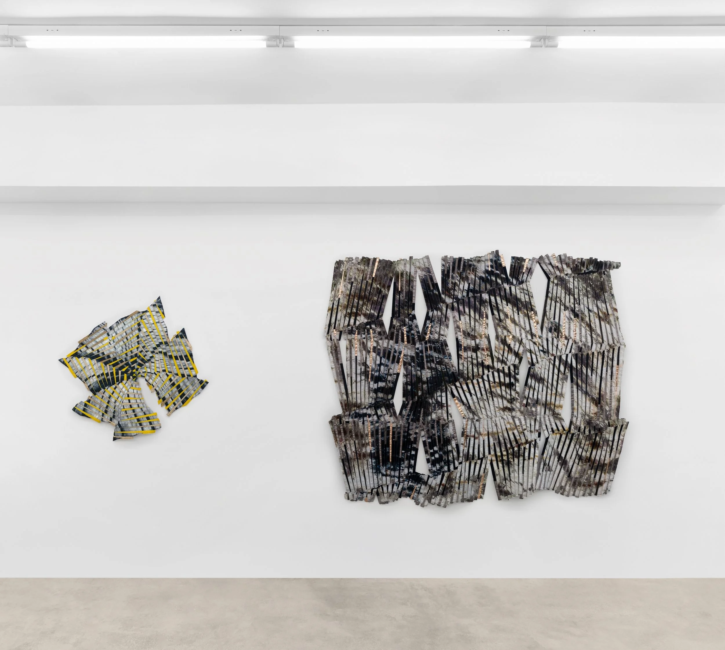 Baker–Hall Gallery - Regina Durante Jestrow: 'Everything Mixing Always' installation view of geometric abstract art quilts made from hand-dyed and found textiles arranged in geometric stripes and triangle patterns in an art gallery with white walls.