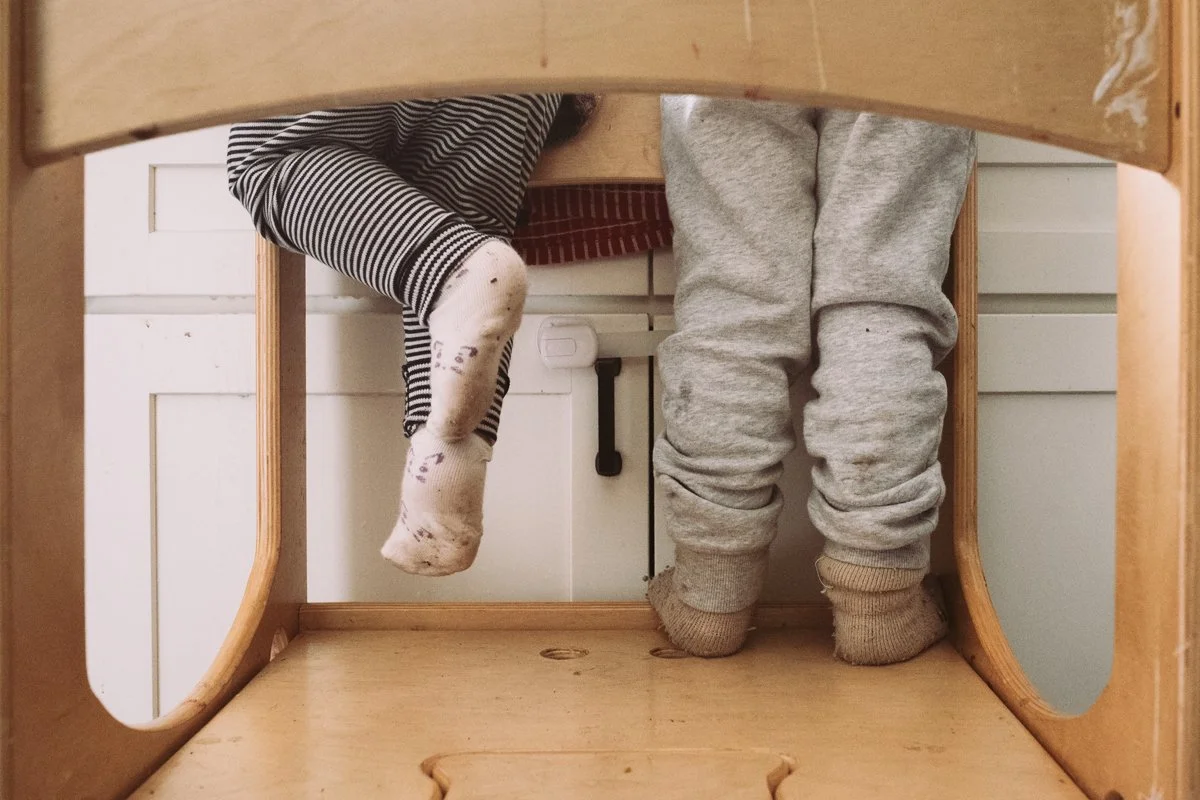 two small childlren in learning tower with dirty socks documentary family photography portland.jpg