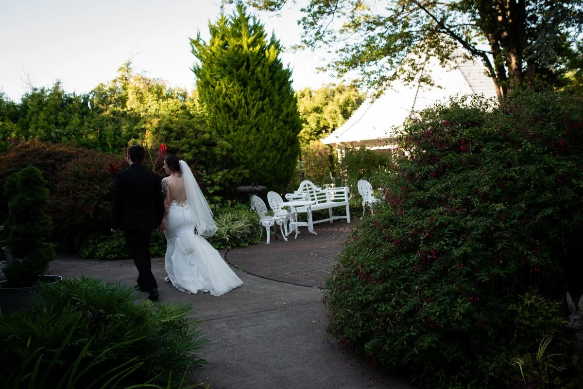 The Belle Victorian Mansion Wedding Photographer Portland. Couple walking through a garden, documentary wedding photographer.