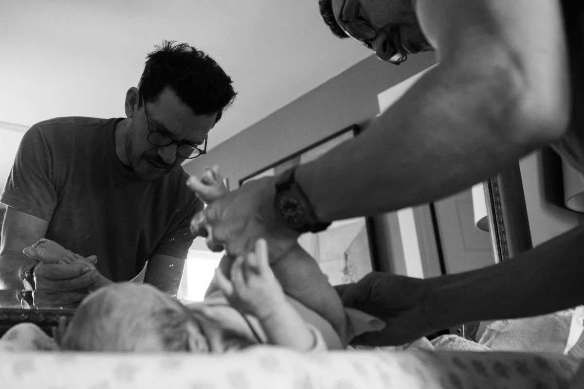Dad changing diaper during a documentary family photography session, black and white. In Portland OR. Documentary, candid, photojournalist photography