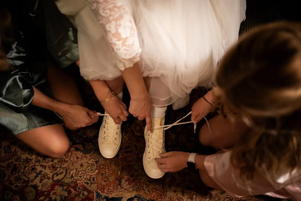 alternative wedding photographer in portland oregon, bride tying her converse shoes