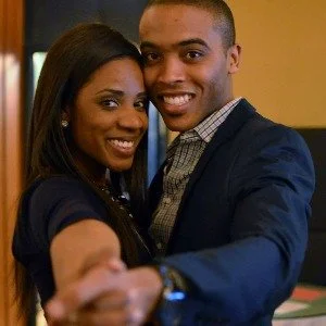 A smiling couple taking a selfie together in an indoor setting.
