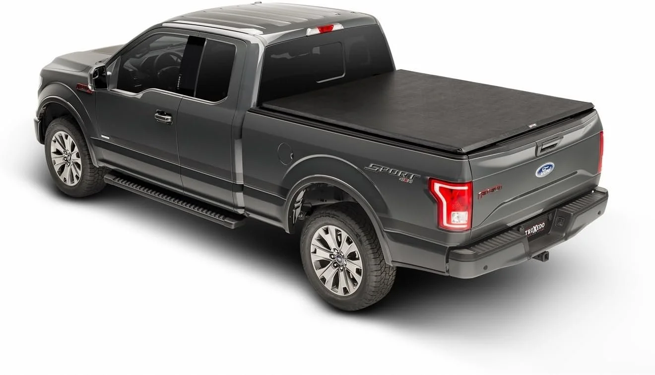 Black Ford F-150 pickup truck with a covered truck bed and running boards, viewed from the back and side.