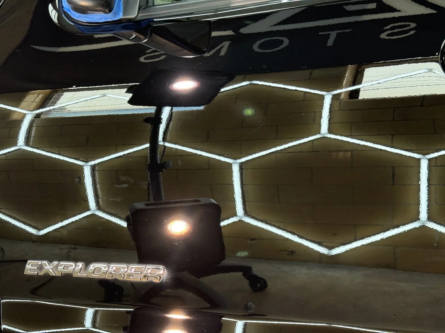 Black SUV parked inside a garage with a sign that reads 'Finesse Customs Window Tint and More' in the background.