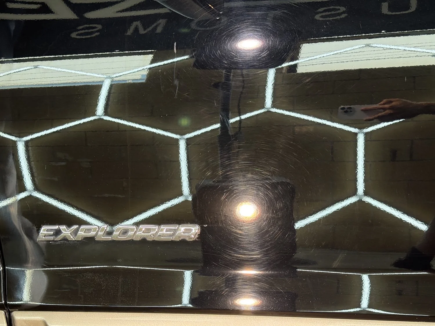 Black SUV parked indoors with visible tires, side steps, and tinted windows.