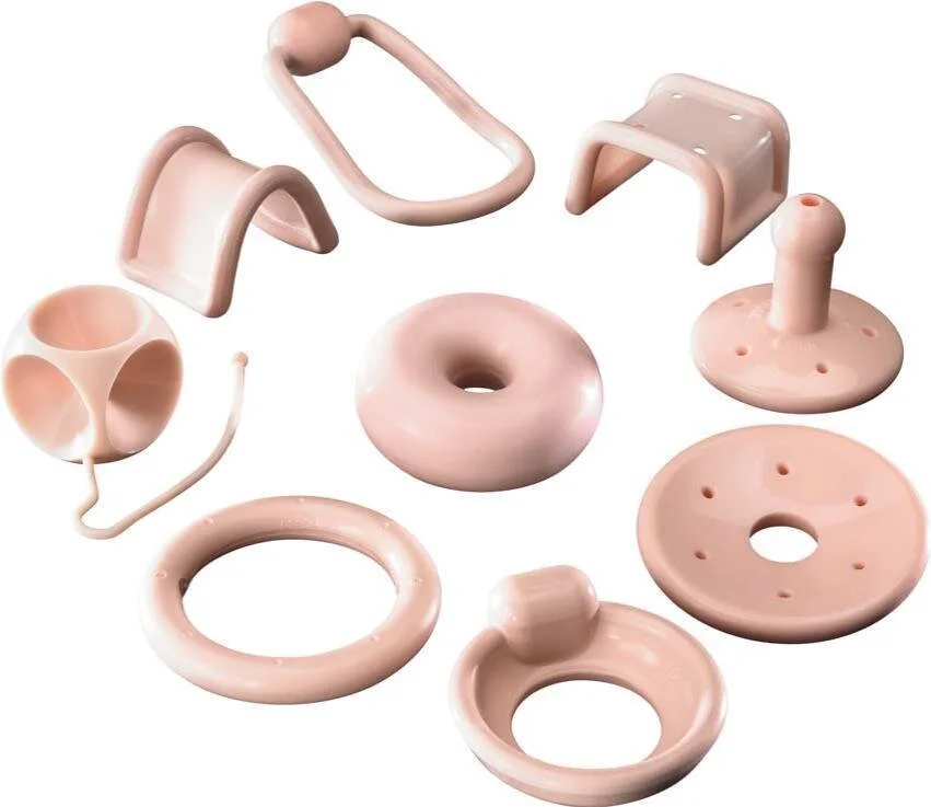 Set of pink plastic toy bathroom accessories including a toilet, a toilet brush, a soap dish, a mirror, a ring, a toilet paper holder, and a plunger.
