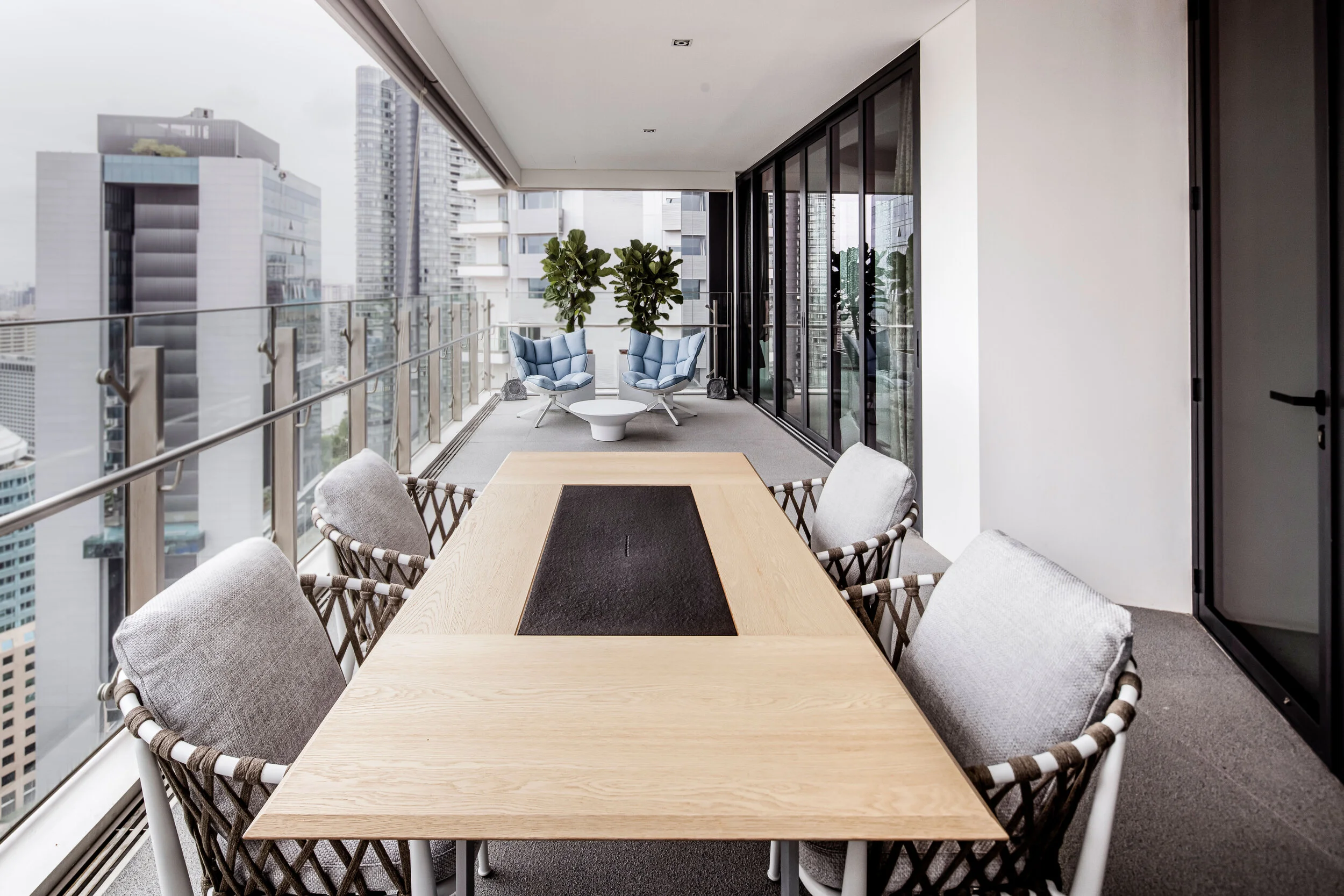 outdoor balcony with long rectangle table and seats