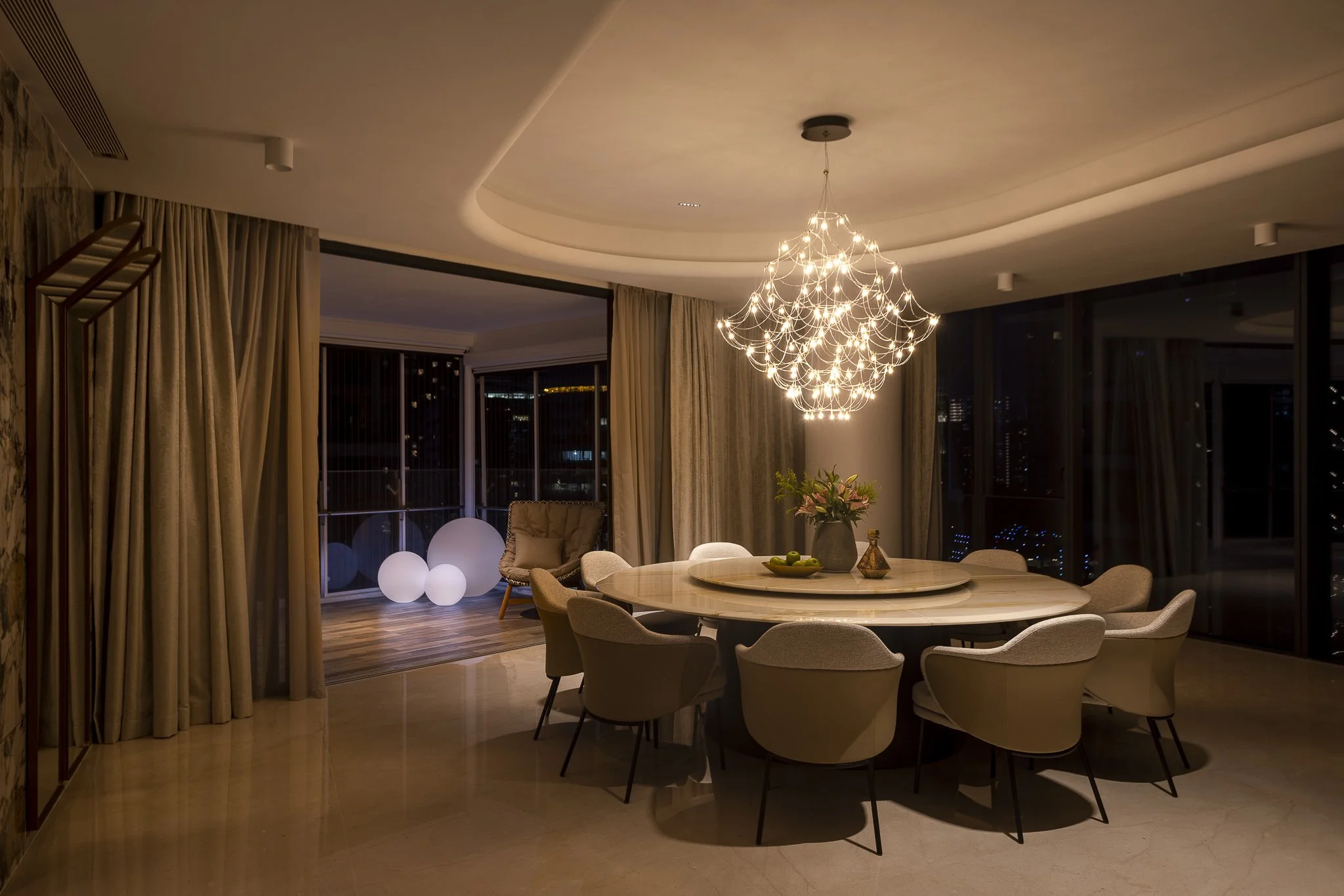 Interior design. Sophisticated modern dining room featuring a chandelier with warm mood lighting.