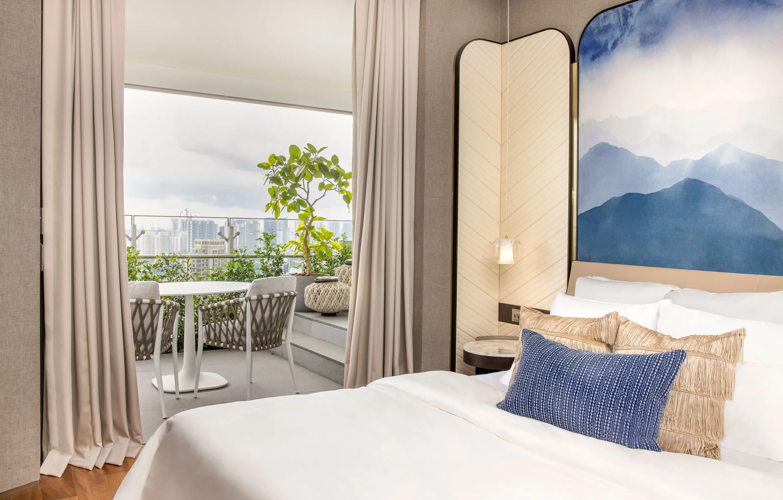 bed next to balcony with outdoor chair and table