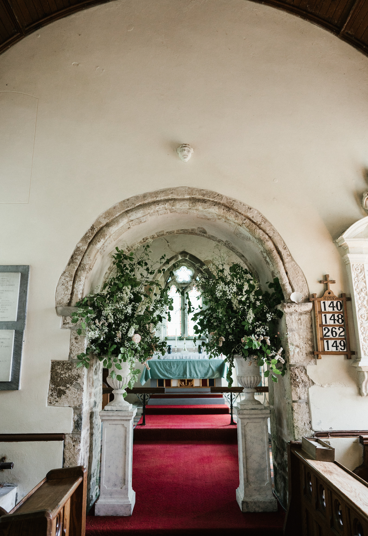 Urns creating a backdrop for wedding ceremony at Penrice Church