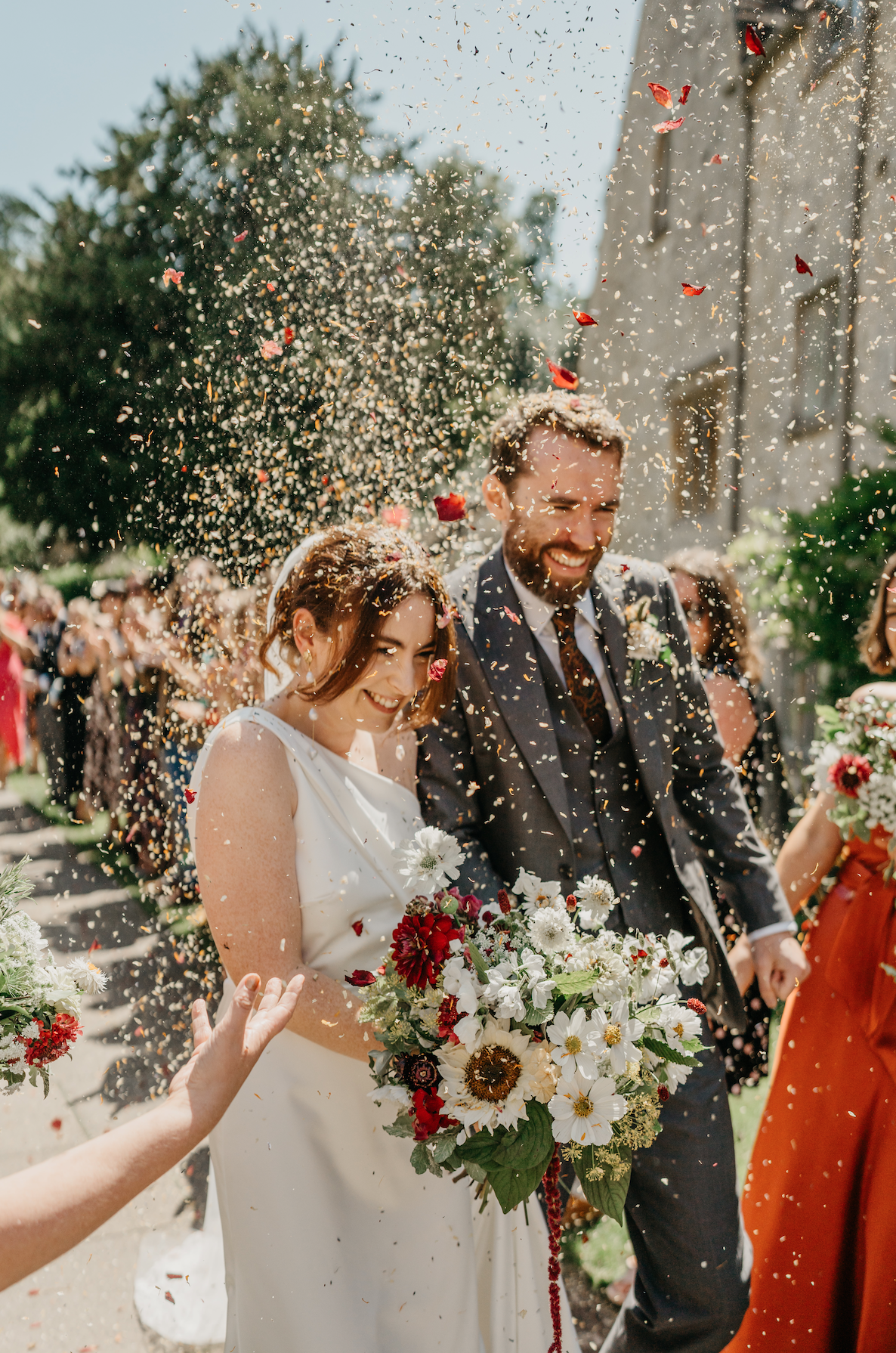 Bride and groom outside St Mary's Church in Bibury, Cotswolds