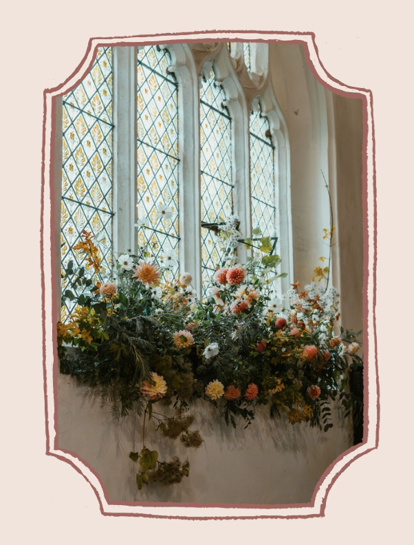Flowers decorating windowsill in Somerset church wedding