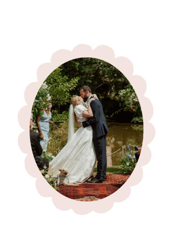 Bride and groom at wedding ceremony at lake in Dewsall Court