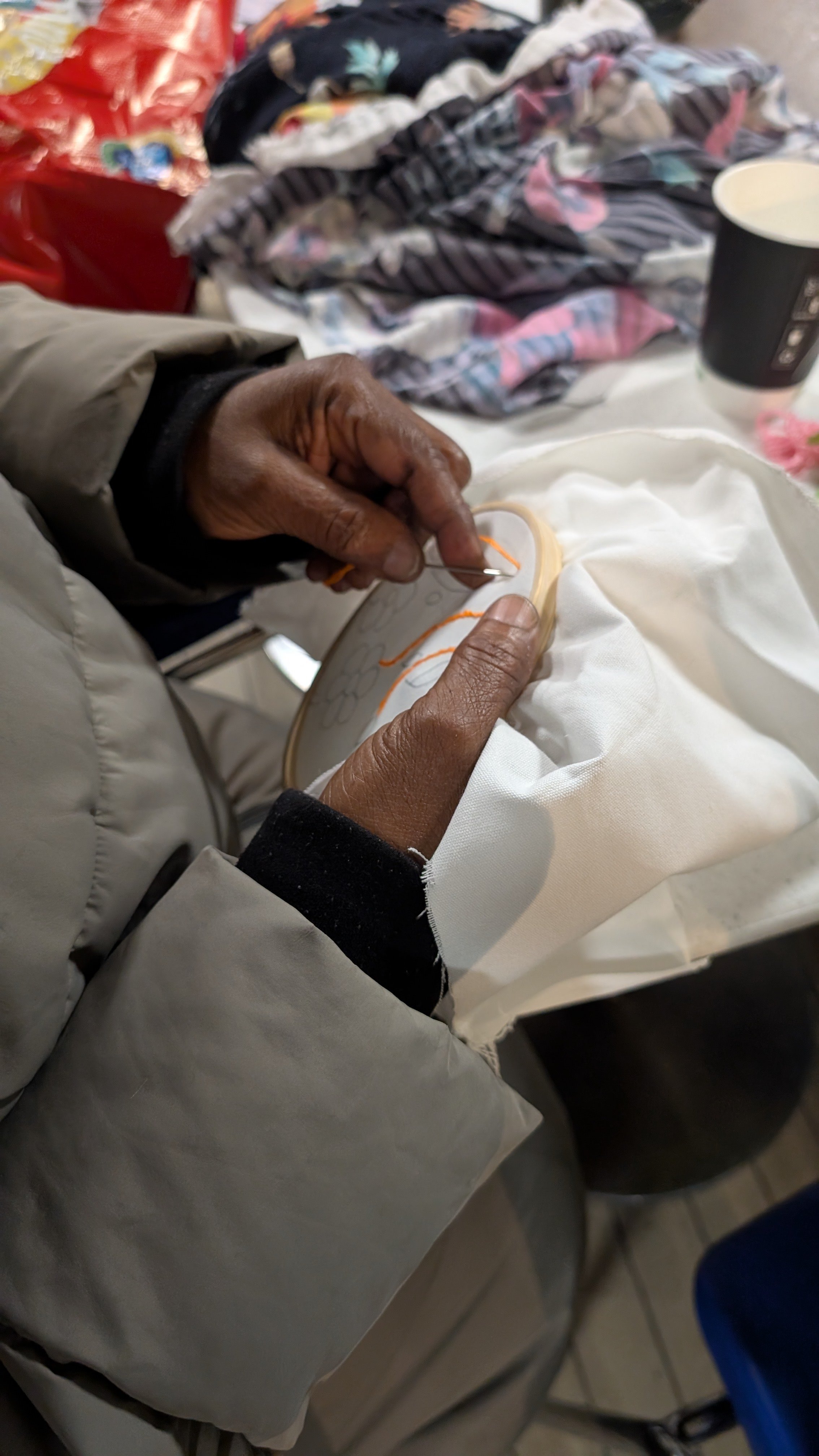 Close up on hands embroidering a flower
