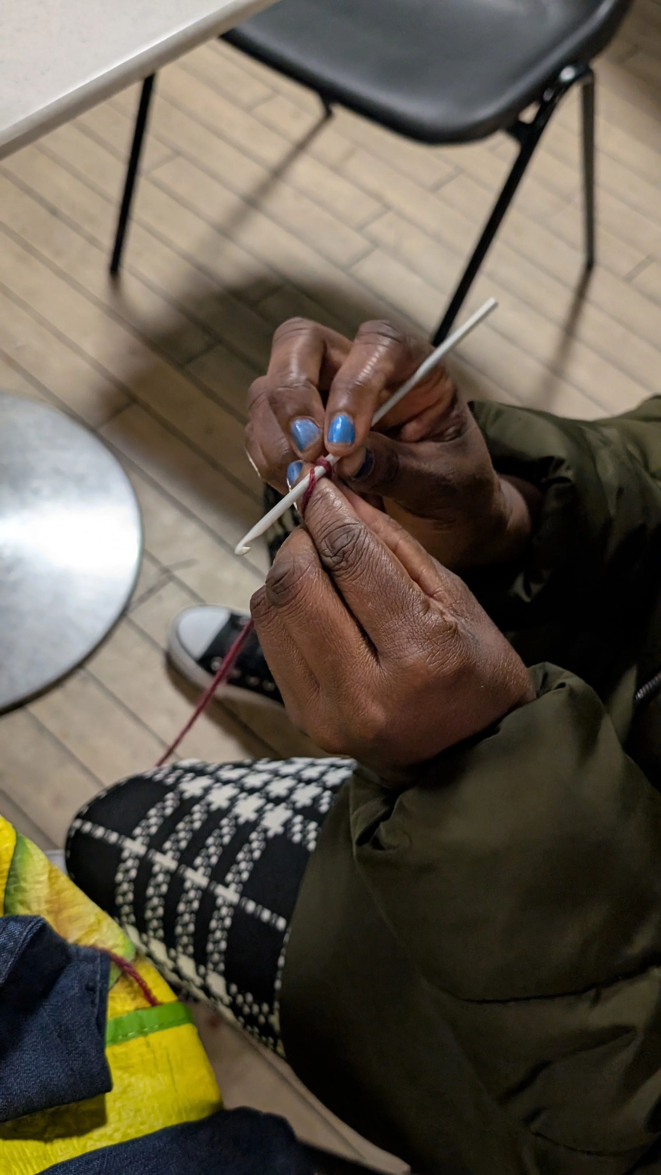 Close up of WAST woman's hands knitting in sewing group