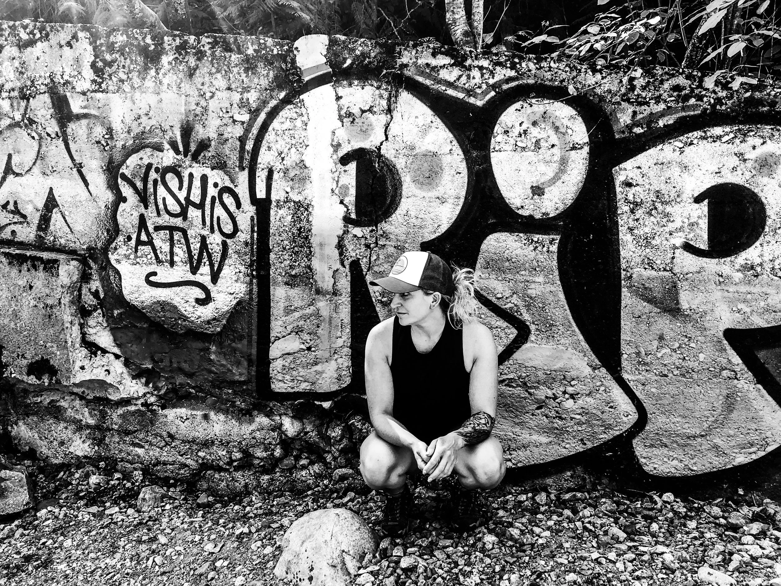 Person standing confidently against a graffiti wall, symbolizing resilience, courage, and personal transformation.