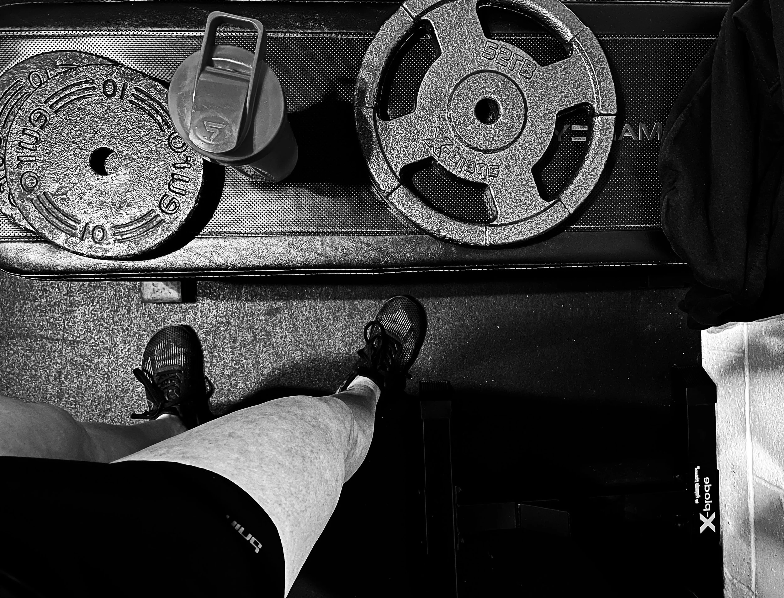 Flat lay of workout weights on the floor beside Melissa's feet, representing discipline, healthy habits, and building resilience through consistent action.
