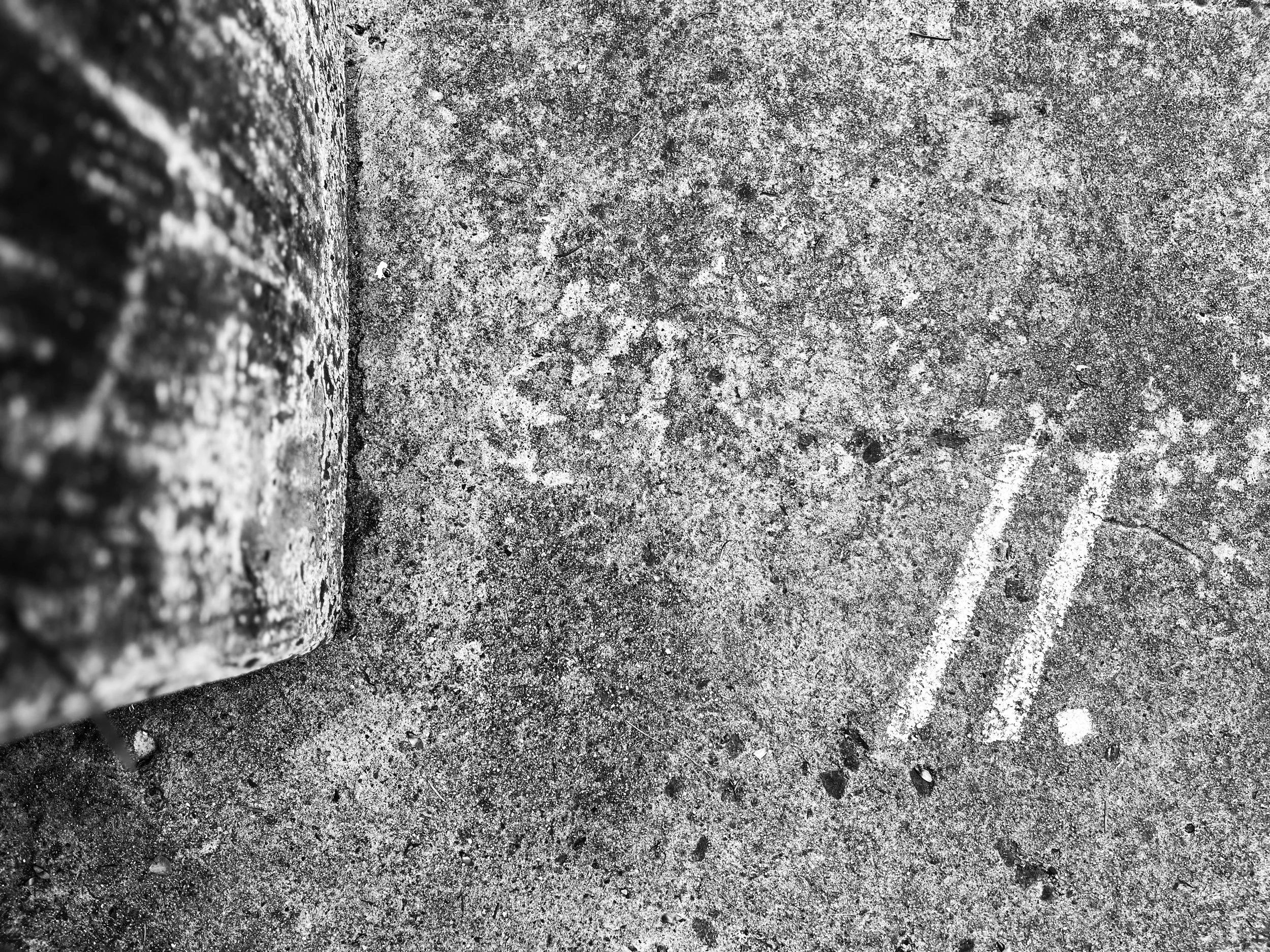 Two chalk slashes drawn on pavement, representing the power of pausing, contemplation, and intentional thinking.