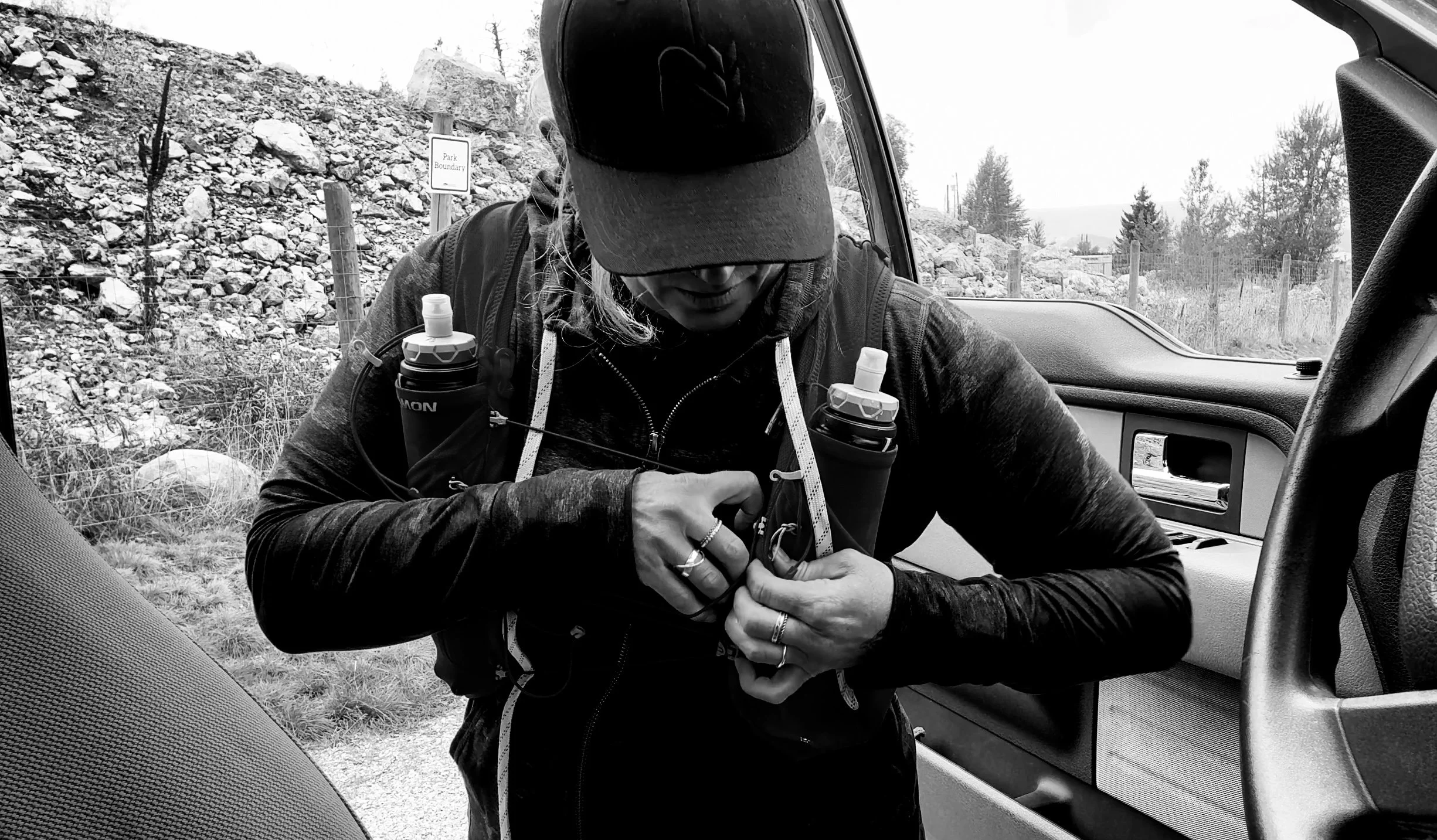 Melissa Lynn Sharp adjusting her hiking gear before setting out on a trail, preparing for the journey ahead.