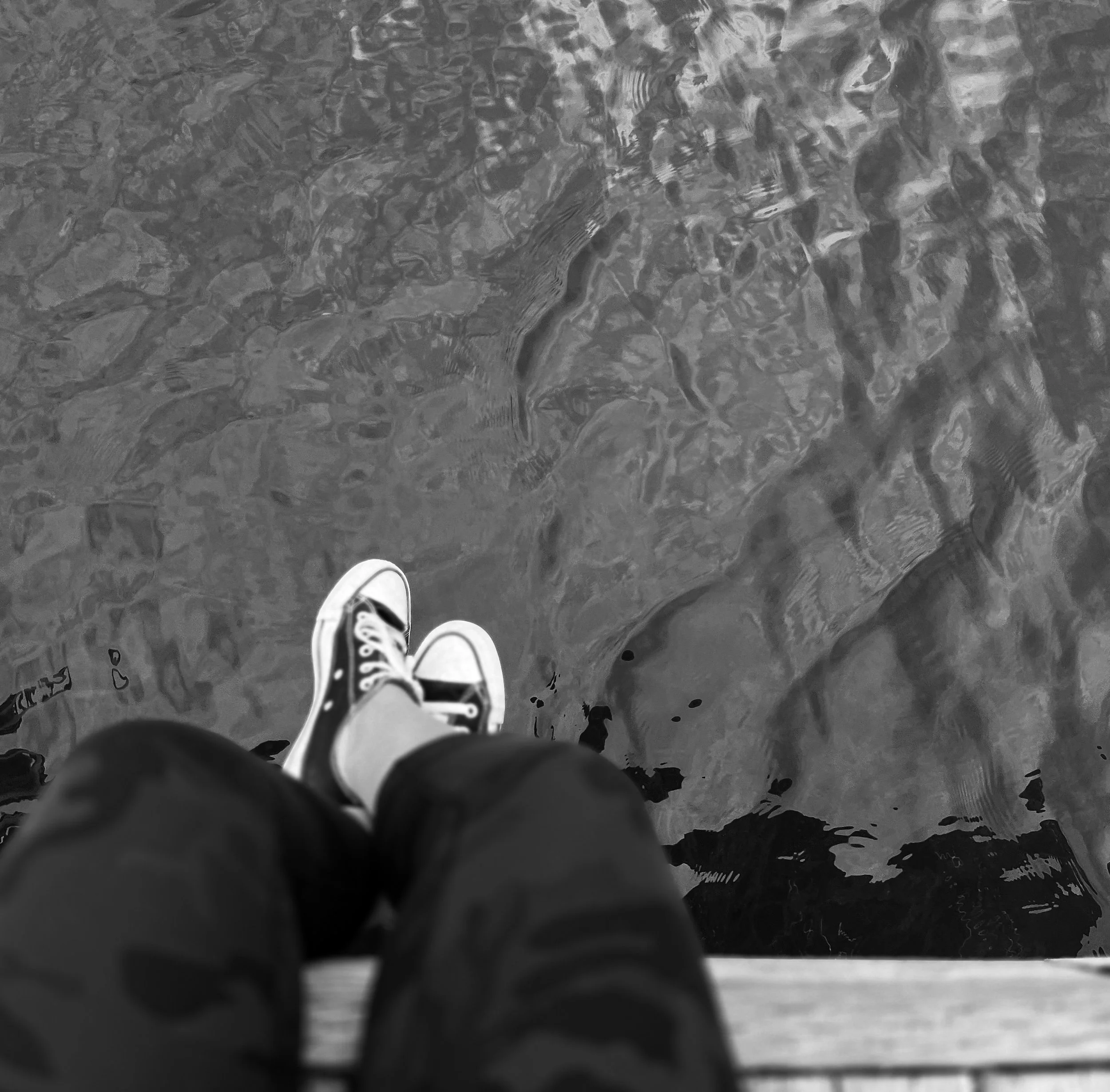 Person sitting quietly on a dock overlooking the water, reflecting on grief, healing, and emotional resilience.