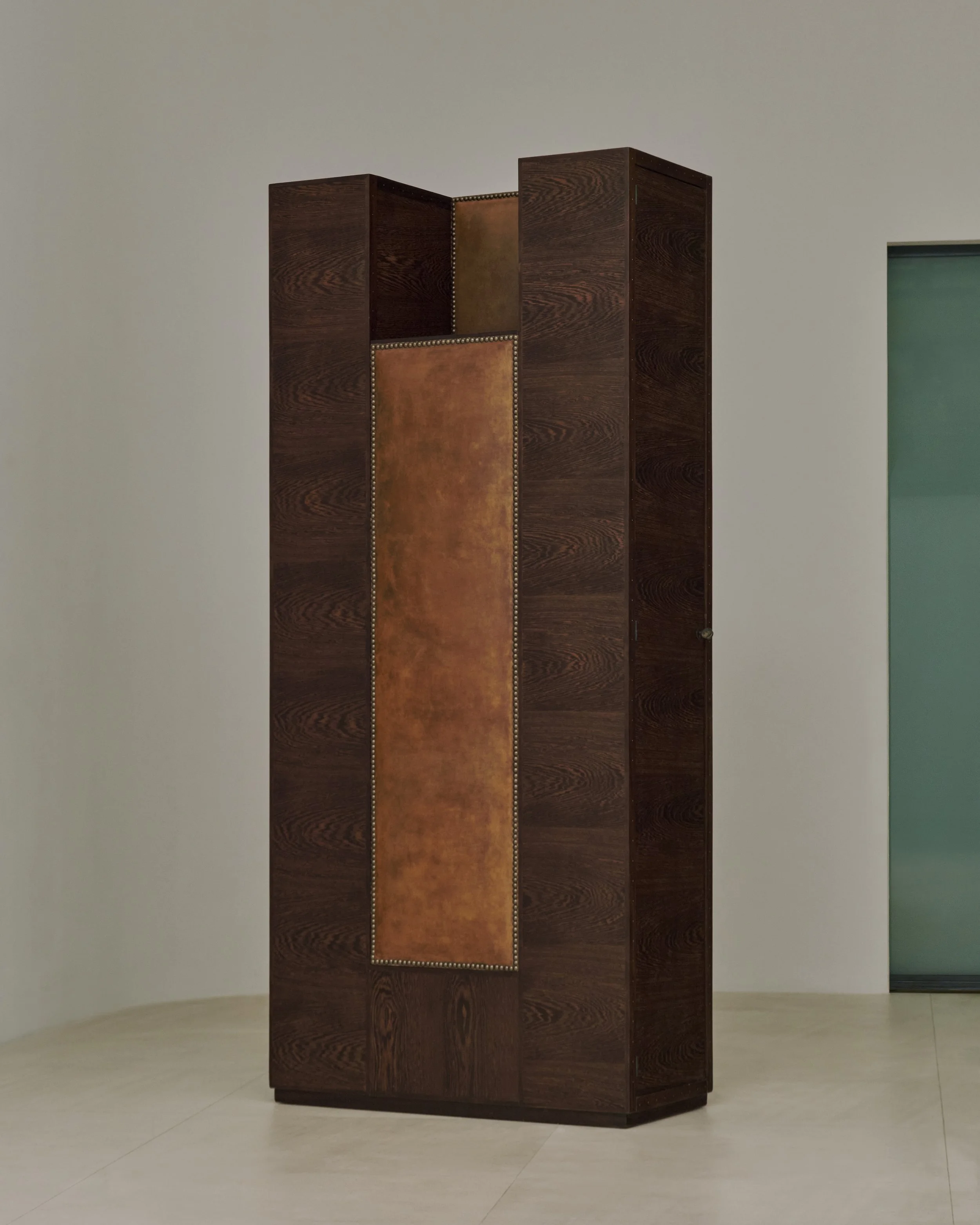 André Sornay, tall cabinet made of exotic wood, featuring a front panel with its original brown leather, circa 1930