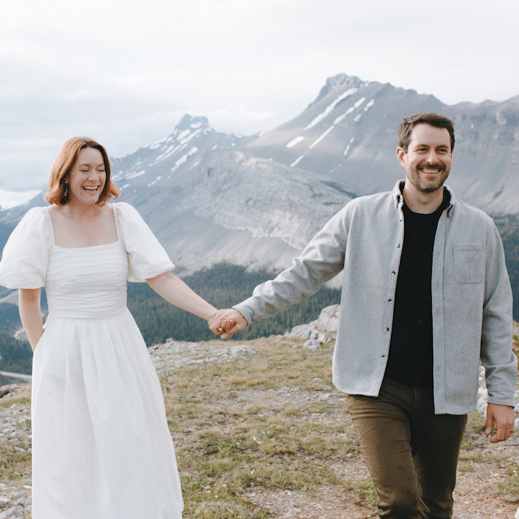 Happy couple holding hands in mountainous outdoor setting