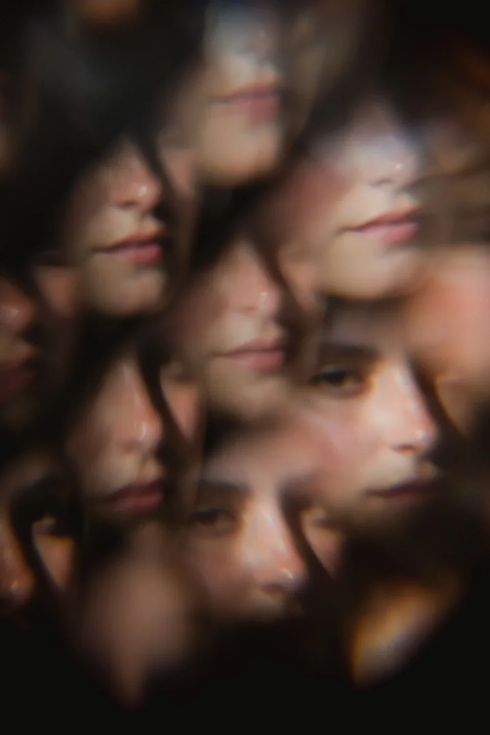 Multiple overlapping close-up portraits of a woman's face with dark hair, with a blurred and distorted effect.