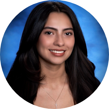 A young woman with long dark hair smiling against a blue studio background.