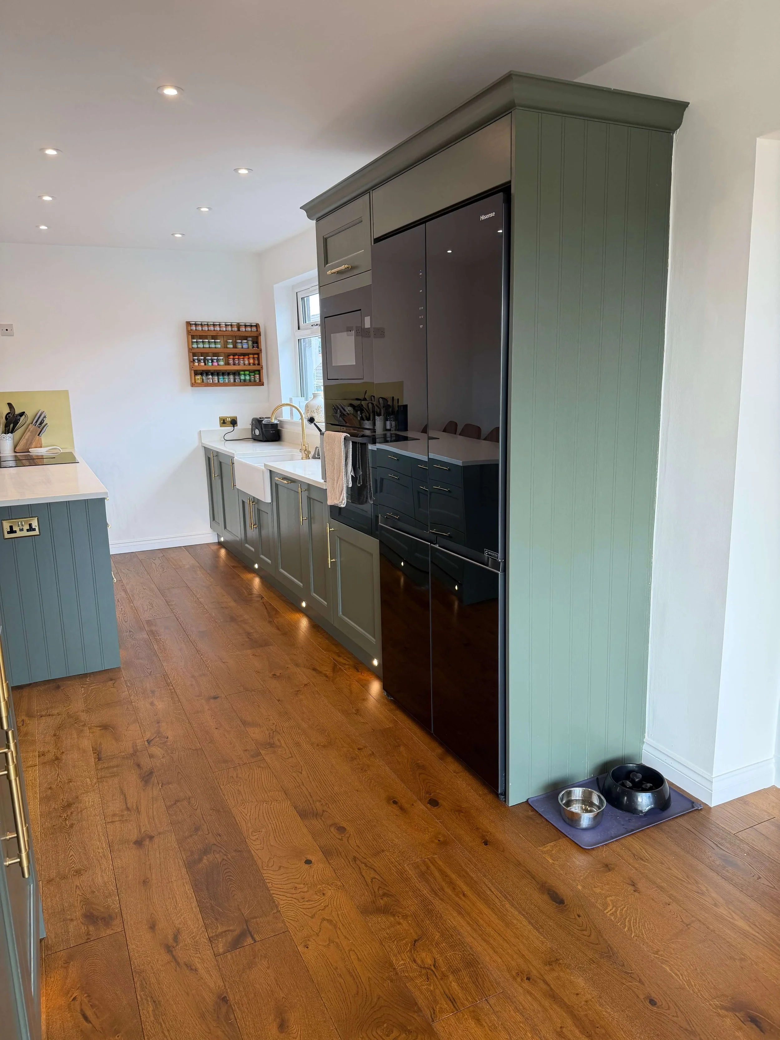 Renovated open-plan kitchen with sage green island and integrated fridge in Lenzie villa