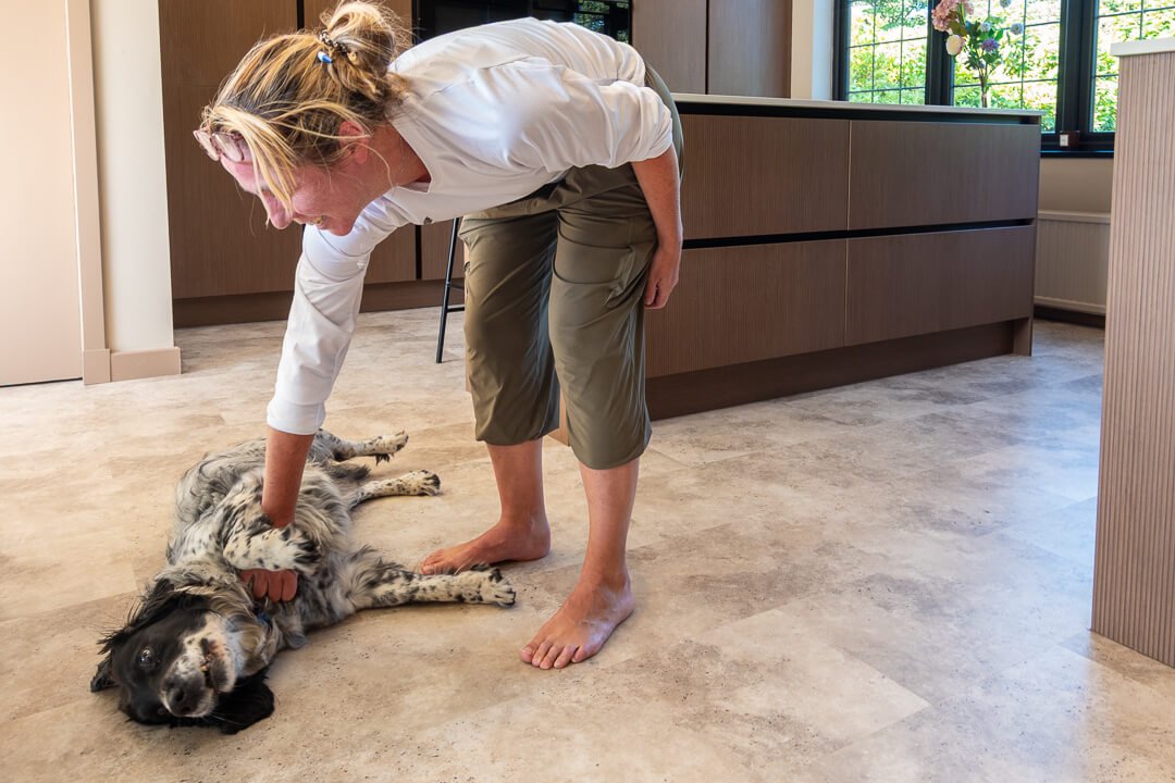 Happy client with her dog on new LVT flooring in redesigned kitchen by Interior Space Design Glasgow