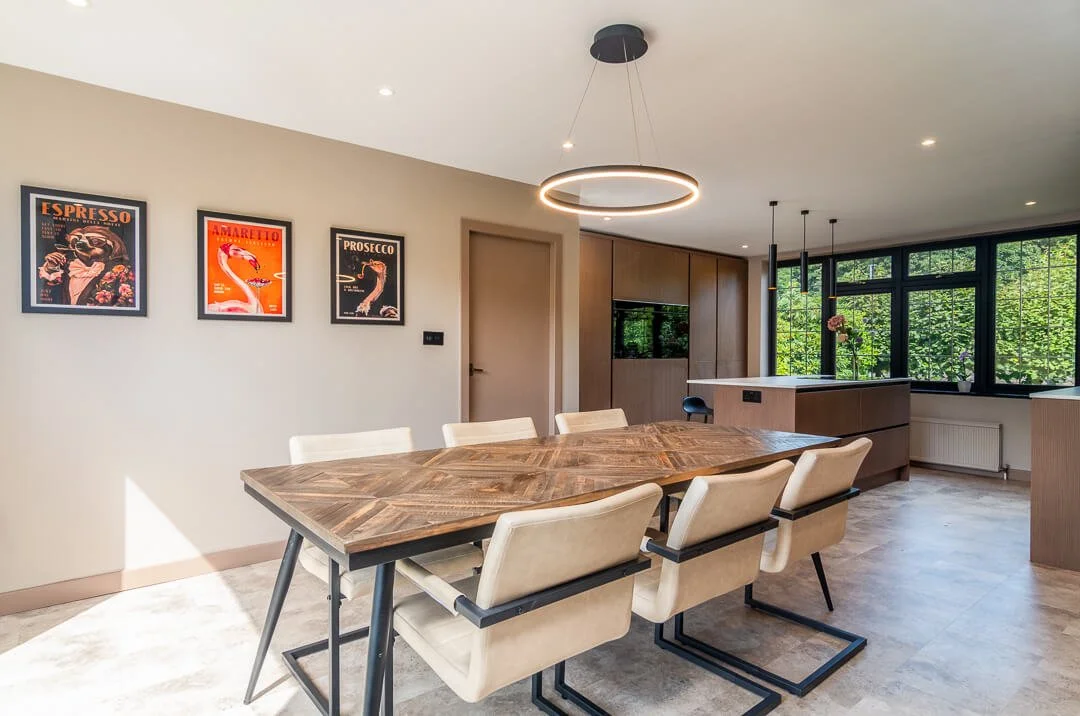 Open plan dining area with circular LED pendant light and kitchen beyond in Bearsden home by Interior Space Design Glasgow