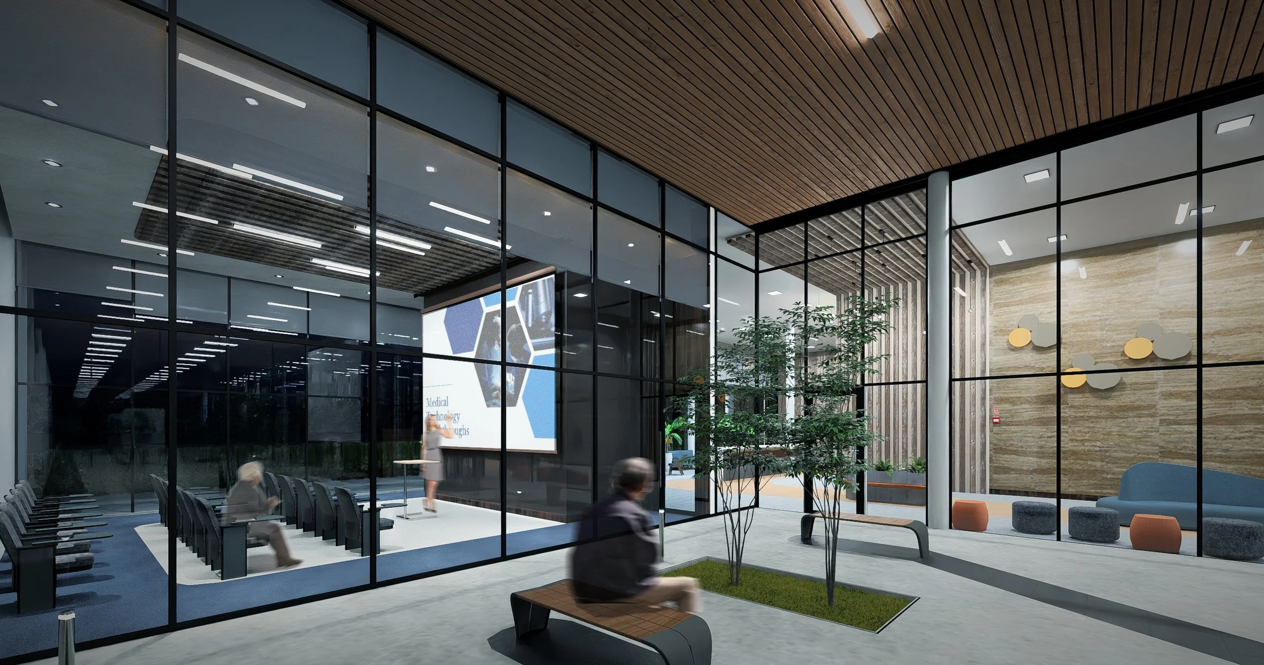 Modern hospital lobby with glass walls, seating area, indoor plants, and a presentation screen for a medical technology conference.