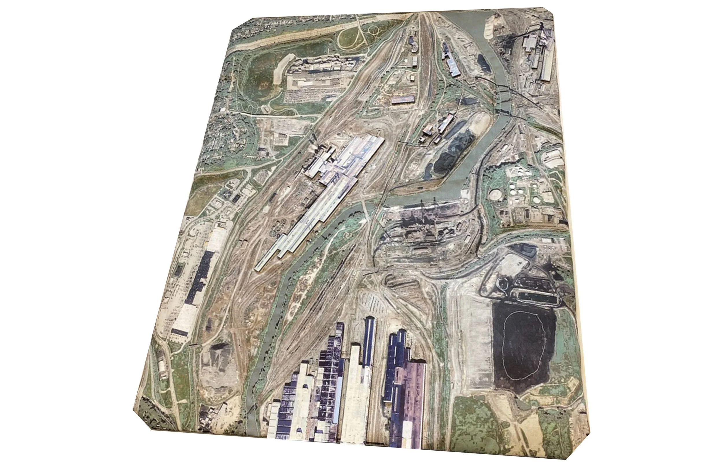 A 3D topographical map displaying an industrial area with railways, waterways, and storage tanks.