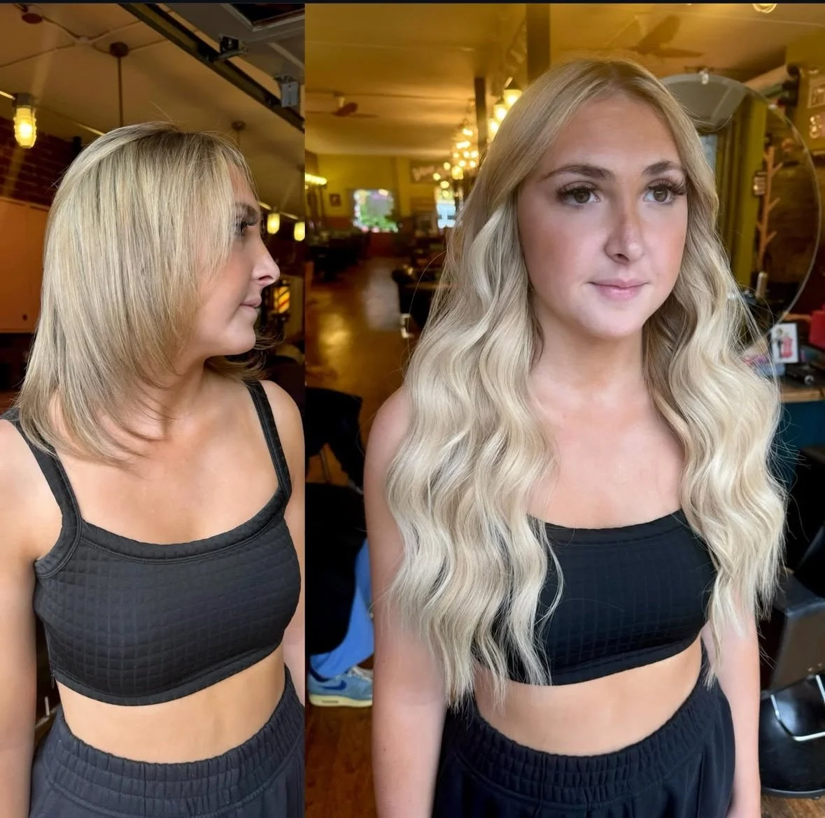 Side view of a woman with shoulder-length blonde hair and a black athletic crop top, looking to the side, in a dimly lit room with hanging lights, in front of a mirror.