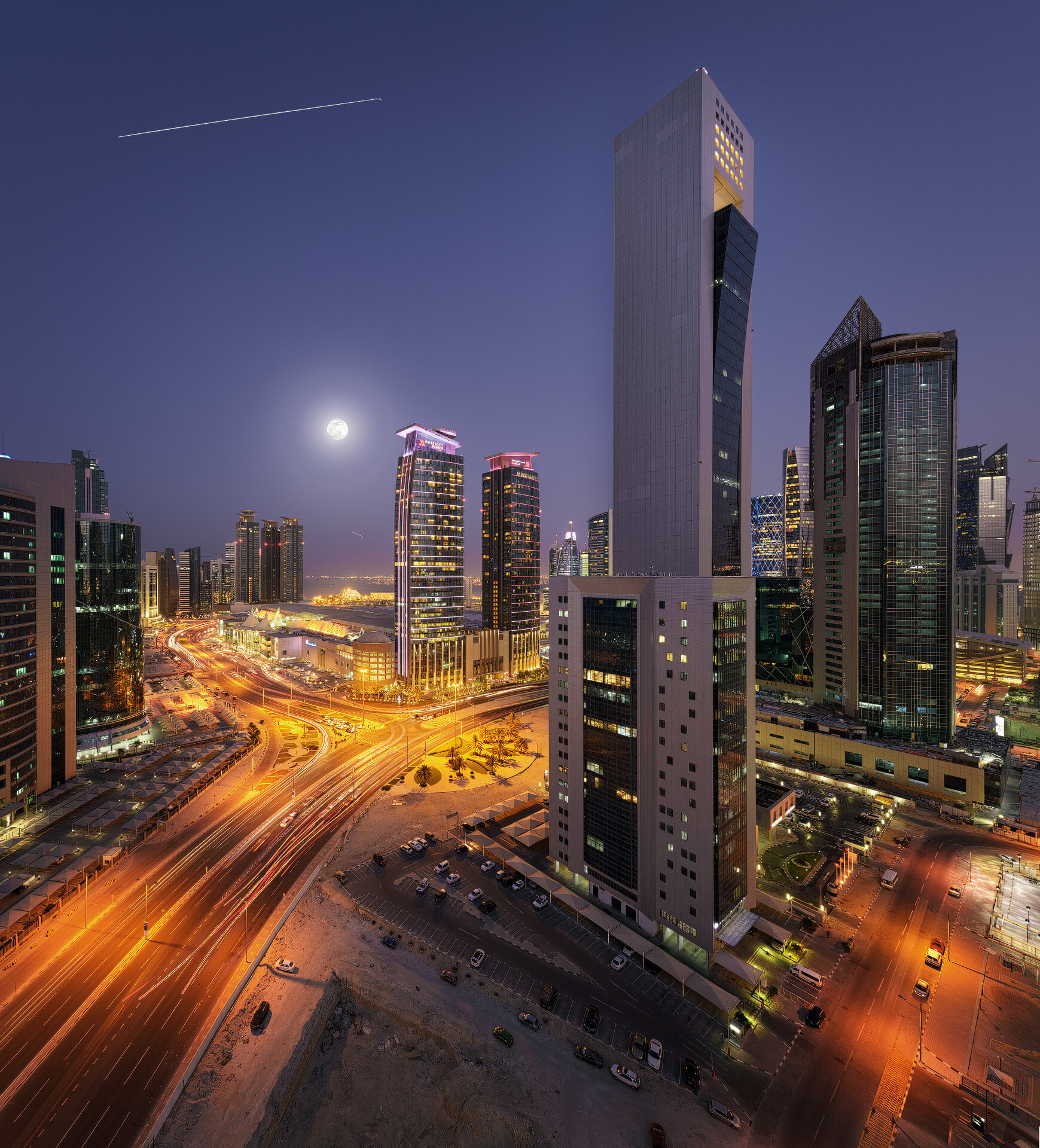 High angle night photograph capturing the International Space Station ISS light trail streak in the sky over West Bay skyscrapers in Doha by Hammad Iqbal