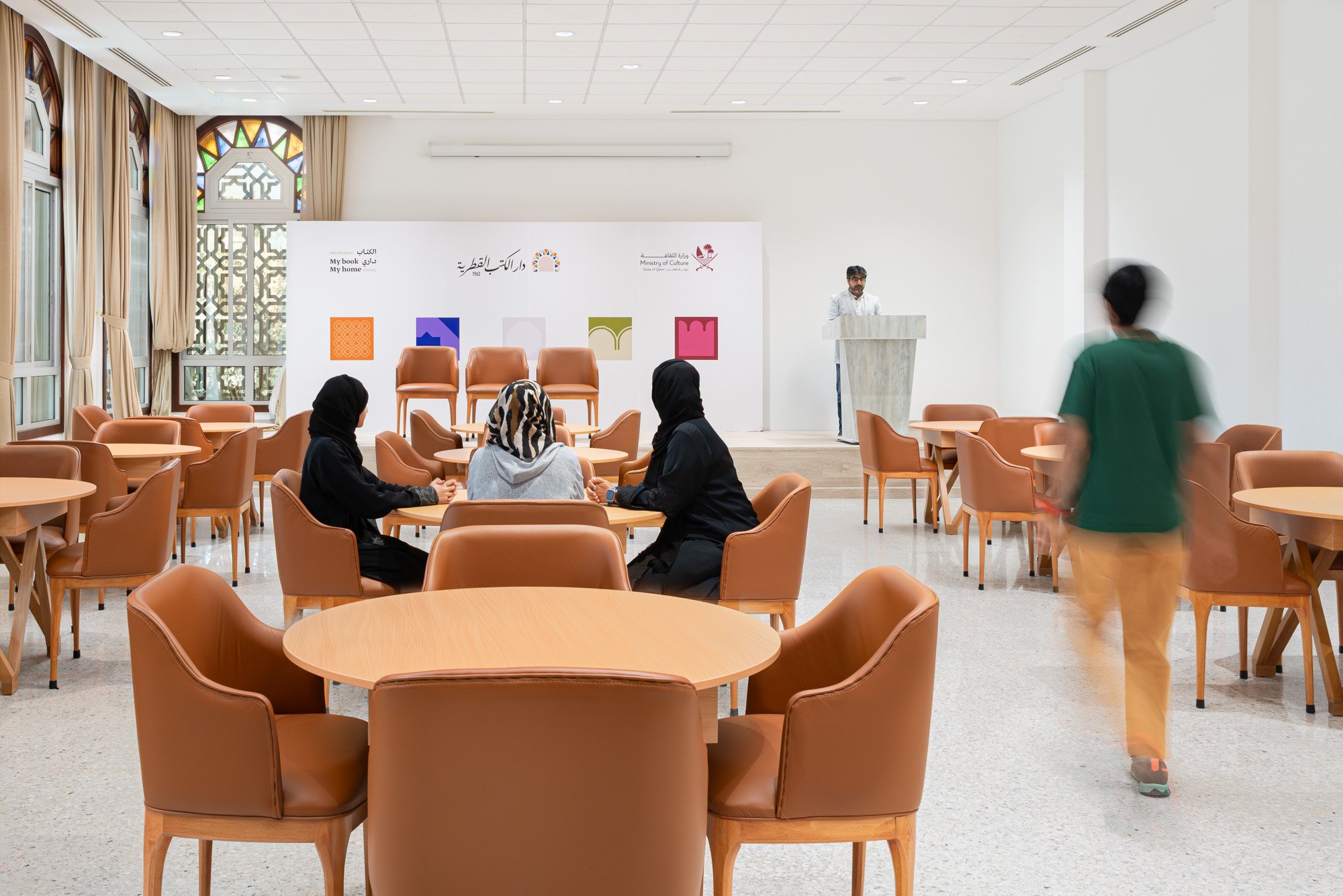 Multipurpose event hall and workshop space at Dar Al Kutub featuring speaker stage and guest seating captured by architectural photographer Hammad Iqbal in Doha