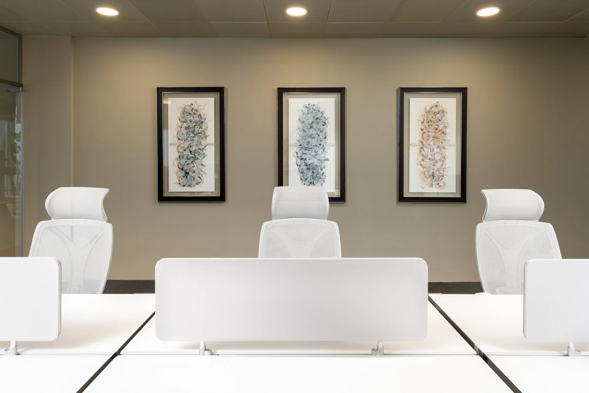 Symmetrical view of white modern office desks framed by Arabic calligraphy artworks in Doha by Hammad Iqbal