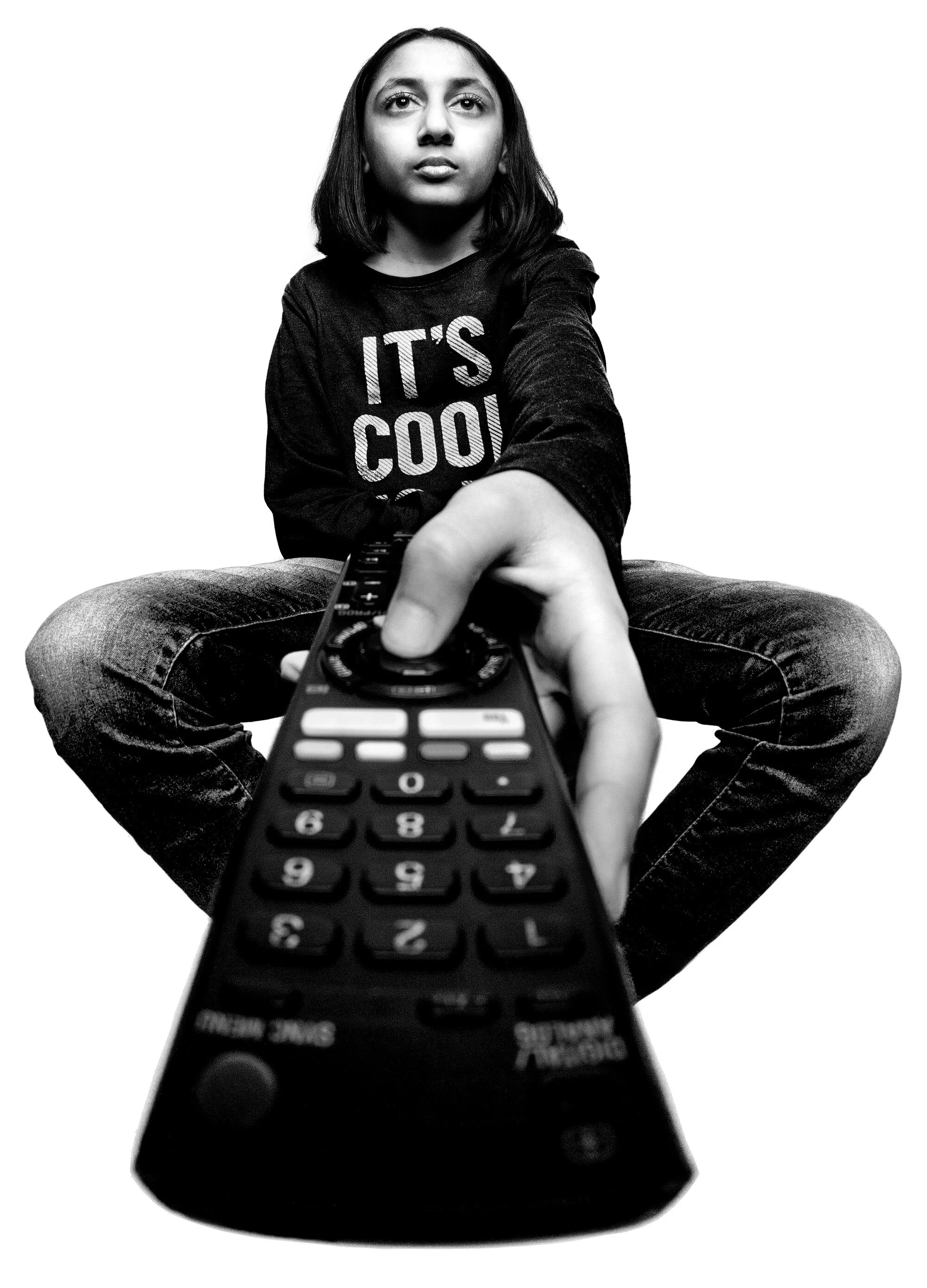 Forced perspective black and white shot of hand holding TV remote toward camera by Hammad Iqbal