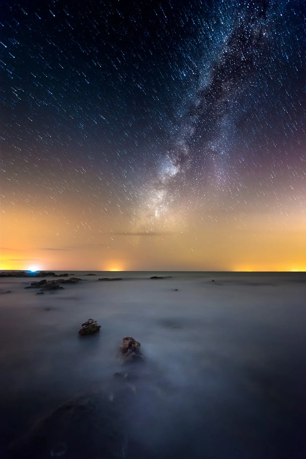 Long exposure astrophotography showing Milky Way core above calm ocean waters along Qatari coastline by Hammad Iqbal