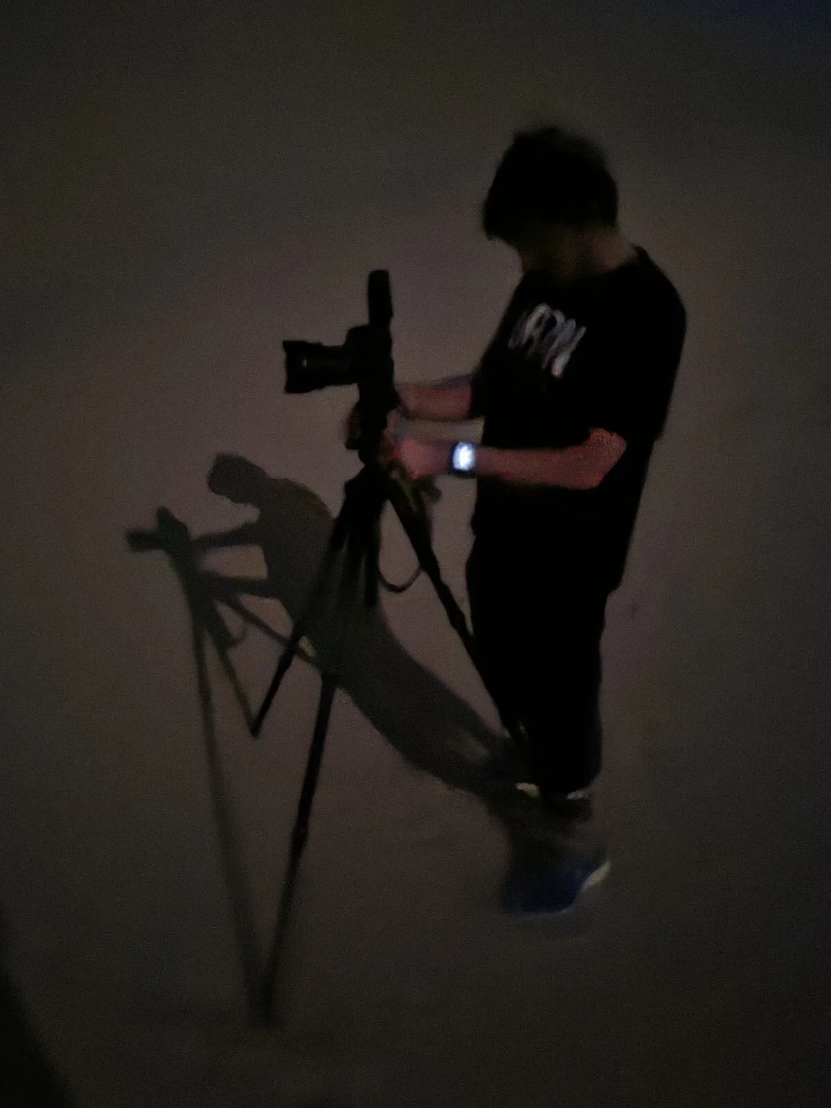 Behind the scenes shot of photographer Hammad Iqbal evaluating exposure and focus on camera screen during a night desert shoot