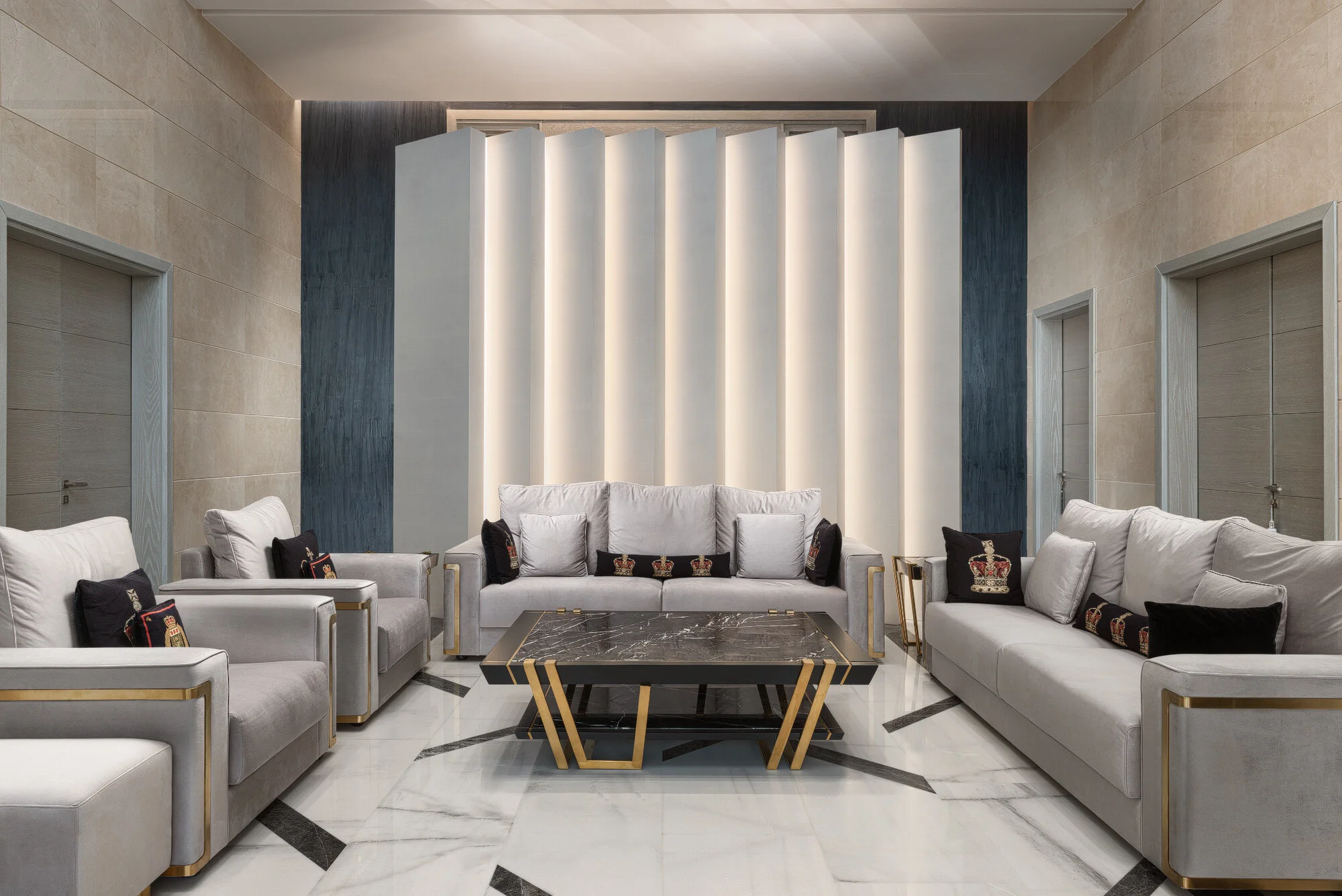 Wide interior shot of a modern luxury majlis with plush white sofas marble coffee table and back-lit architectural wave wall in a West Wukair residence by Hammad Iqbal
